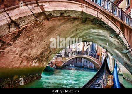 Venezia, Italia - 21 Maggio 2017: Incrocio sotto un ponte e giro in gondola lungo i canali di Venezia, Italia. Foto Stock