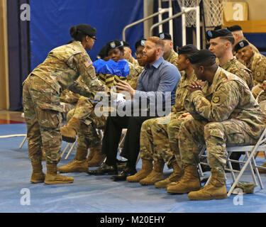 Pvt. 1. Classe Andrea S. Giordania le mani un regalo a Eric Hargrove, sposo della sede e Sede Società, XIX Expeditionary supporto comando in uscita del primo sergente, 1 Sgt. Johanna Y. Castro, durante un cambio di responsabilità cerimonia, gen. 30 presso il Kelly Centro Fitness, Camp Walker, Daegu. Corea. Foto Stock