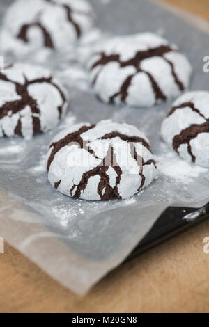 Cioccolato artigianale Crinkle Cookies su un vassoio da forno e tavola di legno Foto Stock