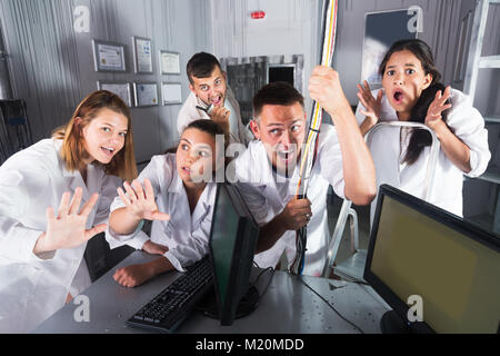 Felice cinque adulti emotivamente e allegramente in posa di camici da laboratorio in camera ricerca Foto Stock