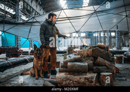 Stalker con il suo animale domestico contro il camino, l'uomo vive in un mondo apocalittico. Post-apocalypse lifestyle su rovine, il giorno del giudizio universale, il giorno del giudizio Foto Stock