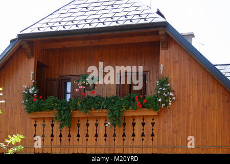 Balcone in legno decorato con gerani Foto Stock