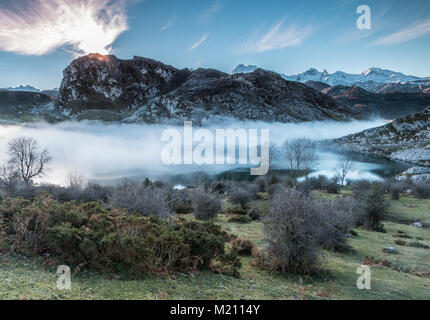 Spettacolare e colorato tramonto nei laghi di Covadonga, Asturias, in una fredda giornata invernale, dove si possono vedere i bei colori delle nubi, Foto Stock