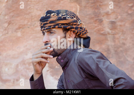 WADI RUM CAMP, Giordania - 30 Aprile 2016: uomo beduino nel Wadi Rum di fumare una sigaretta Foto Stock