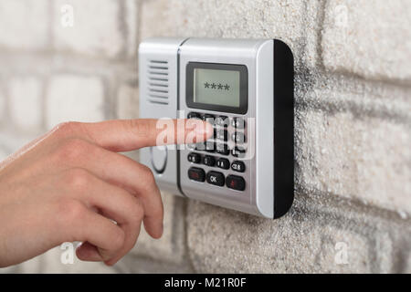 Close-up di mano di una persona sulla sicurezza tastiera allarme Inserimento del codice di protezione Foto Stock