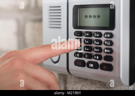 Close-up di mano di una persona sulla sicurezza tastiera allarme Inserimento del codice di protezione Foto Stock