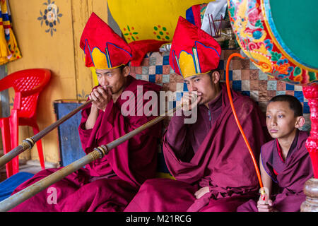 Prakhar Lhakhang, Bumthang, Bhutan. I monaci buddisti giocando il Dungchen lungo (tromba), giovane monaco suonare il tamburo. Foto Stock