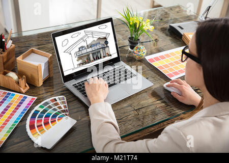 Un architetto lavora con i campioni di colori per la selezione utilizzando Laptop Foto Stock