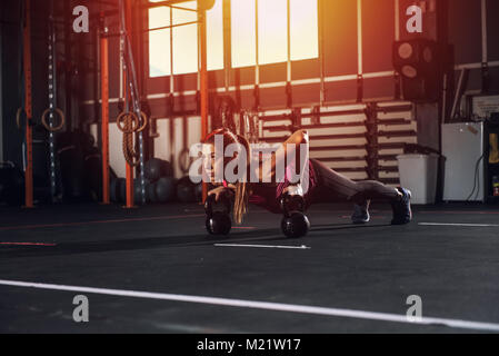 Athletic ragazza lavora presso la palestra con una kettlebell Foto Stock