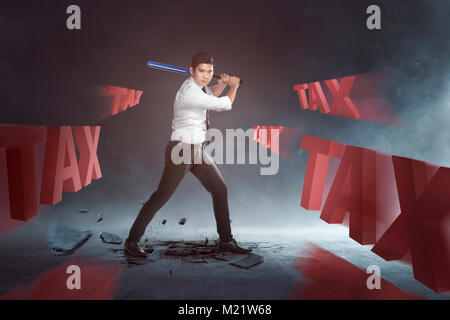 Bello imprenditore asiatici swinging mazza da baseball di tassare il testo su sfondo nero Foto Stock