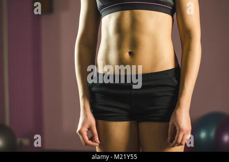 Pancia piatta del giovane femmina la formazione presso il fitness club, bella sana fit Foto Stock