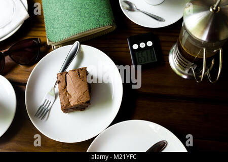 Brownie e verde notebook fatti a mano su una tavola (aperto). Decorazione di caffè. Foto Stock