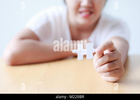 Donna Asiatica che mostra puzzle di profondità di campo per selezionare la messa a fuoco sulle mani Foto Stock