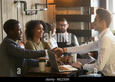 E multirazziale e africani uomini caucasici di handshaking in riunione Foto Stock