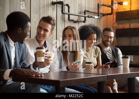 Felice multi-etnico gruppo di amici a parlare utilizzando smartphone alla Foto Stock