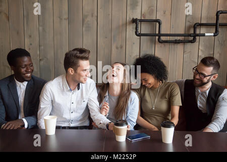 Uomo caucasico scherzando presso il cafe incontro rendendo multirazziale amici Foto Stock