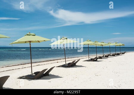 Le sedie a sdraio e gli ombrelloni su un tropicale, spiaggia bianca Foto Stock