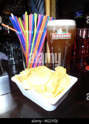 Una pinta di progetto di Kilkenny cream ale con un lato di patatine/chips preso in un bar a Fuengirola, Spagna Foto Stock