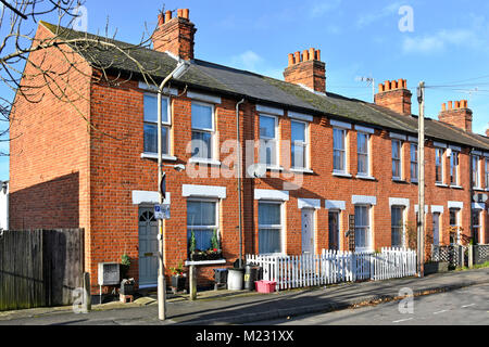 Le case a schiera in una strada residenziale di case in mattoni rossi consentono il parcheggio con un cartello di restrizione e un piccolo giardino frontale Brentwood Essex Inghilterra Regno Unito Foto Stock