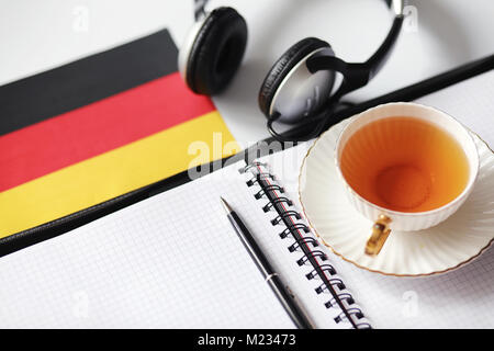 L apprendimento delle lingue straniere. Blocco note per voci e una bandiera. Lang Foto Stock