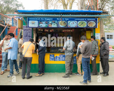 Ooty, Tamil Nadu, India. 01/08/2018. Documentario. Non identificato gli uomini locale comprando qualcosa su una stazione ferroviaria store. Foto Stock