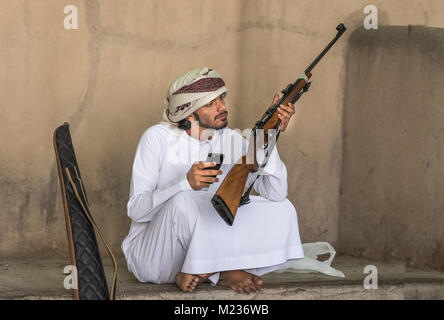 Nizwa, Oman, febbraio 2nd, 2018: omani uomo con un fucile da caccia a un mercato Foto Stock