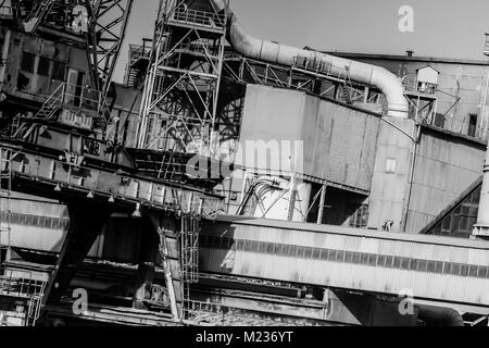 Cantiere di Danzica, Polonia. In stile retrò in bianco e nero. Gru, il cantiere di vecchi edifici, strutture arrugginite. Foto Stock