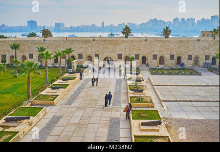 Alessandria, Egitto - 17 dicembre 2017: La vista dalle mura del castello di Qaitbay Fort sul suo vicolo centrale con cannoni, il giardino delle palme, bastioni e th Foto Stock