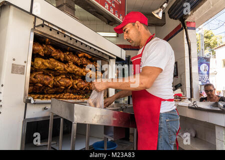 Uomo che serve pollo caldo sulla strada a Puerto Vallarta, Messico. Foto Stock