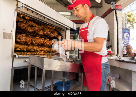 Uomo che serve pollo caldo sulla strada a Puerto Vallarta, Messico. Foto Stock