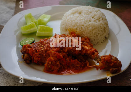 Tipico piatto indonesiano: Nasi Ayam Plecing (pollo con riso e salsa speciale). Foto Stock