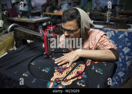 Unità di rilegatura di esperti a lavorare in una fabbrica di indumento nella Vecchia Delhi, India Foto Stock