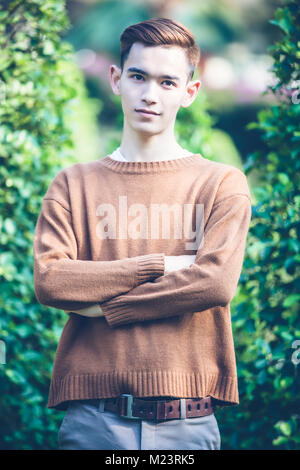 Asian uomo bello modello sorridente in posizione di parcheggio Foto Stock