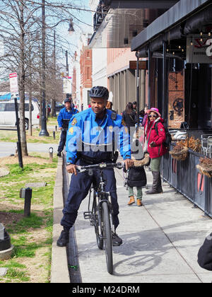 Americano africano, o nero, funzionario di polizia su una bicicletta conduce la pattuglia di routine su un marciapiede in città nel centro di Montgomery in Alabama, Stati Uniti. Foto Stock