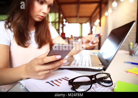 Giovane donna tenendo la carta di credito e con il computer portatile. Shopping online concetto. Foto Stock