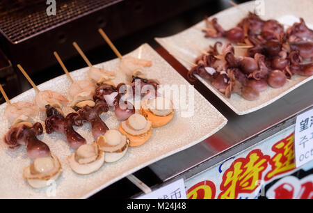Giapponese il cibo di strada, spiedini di pesce, capesante alla griglia Hotateyaki, polipetti Takotamago e gamberetti su un bastone a Kyoto, Giappone Foto Stock
