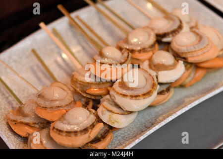 Giapponese il cibo di strada, capesante grigliate, Hotate-yaki, su un bastone a Kyoto, Giappone Foto Stock