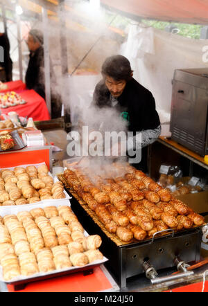 Cibo di strada di vendita del fornitore grigliate di pancetta avvolto palle di riso, Nikumaki Onigiri, Giapponese street market alimentare a Kyoto, Giappone Foto Stock