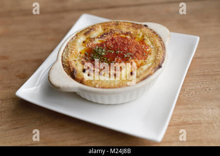 Vegano marrone cremosa casseruola di riso con salsa bianca, piatto su una tavola di legno, cibo vegetariano ancora in vita. Kyoto, Giappone. Foto Stock