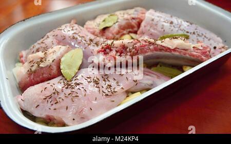 Pezzi di un crudo condito di coniglio e carne di maiale in una teglia. Foto Stock