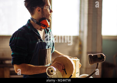 Attraente uomo iniziare facendo lavori in legno in falegnameria Foto Stock