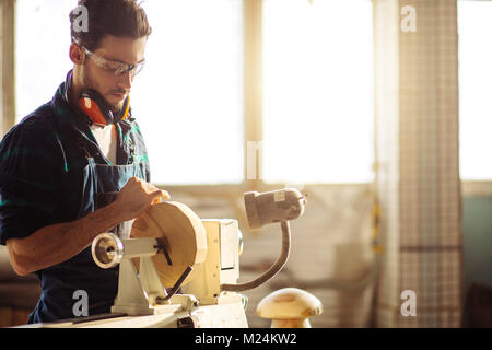 Attraente uomo iniziare facendo lavori in legno in falegnameria Foto Stock