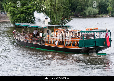 Un vapore alimentato piacere barca manovre attorno ad una piccola isola, il fiume Tamigi, Windsor, Berkshire, Inghilterra, Regno Unito. Foto Stock