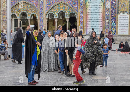 Tehran, Iran - 27 Aprile 2017: gruppo di uomini iraniani, le donne e i bambini stanno prendendo le foto nelle vicinanze lo Shah Abdol Azim Santuario. Foto Stock