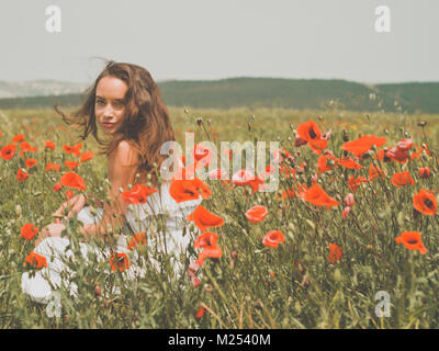 Foto esterna della bella giovane donna nel campo di papavero Foto Stock