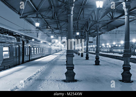 Vista notturna della stazione piattaforme a freddo nevoso inverno. Foto Stock