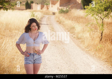 Bella ragazza denim da indossare pantaloncini corti e top in campagna Foto Stock