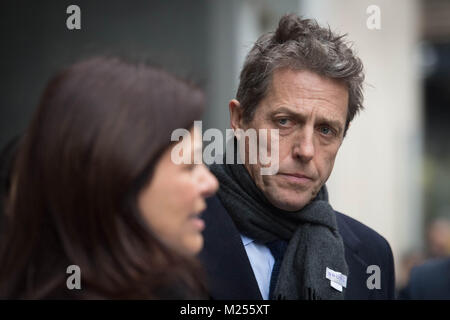 Attore Hugh Grant e Crimewatch presenter Jacqui finimenti lasciare i rotoli Building a Londra dopo che si stabilirono il loro telefono hacking rivendicazioni contro la Mirror Group quotidiani e News Group di quotidiani, editori di notizie del mondo. Foto Stock