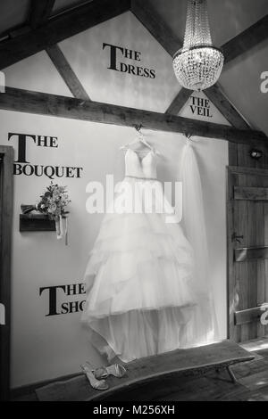 Abito da sposa, velo e bouquet nuziale in shop display, B&W Foto Stock