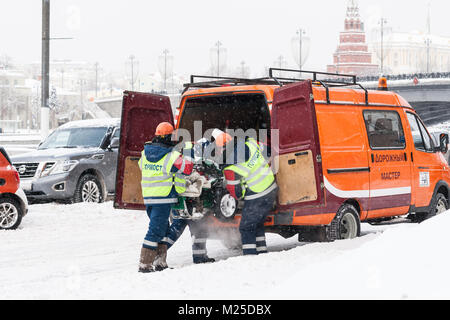 Meteo russa di Mosca. Lunedì, 5 febbraio 2018. La città si ravviva dopo la norma mensile di neve ha ottenuto lo scorso weekend. Servizi municipali di mobilitare tutte le loro risorse per pulire le strade e le piazze dallo spessore del tappeto bianco di fiocchi di neve. La temperatura è bassa, -10C (14F), ancora la luce della neve. Unidentified, irriconoscibili i lavoratori di sesso maschile un carico neve rimozione della macchina in un servizio van. Credito: Alex Immagini/Alamy Live News Foto Stock